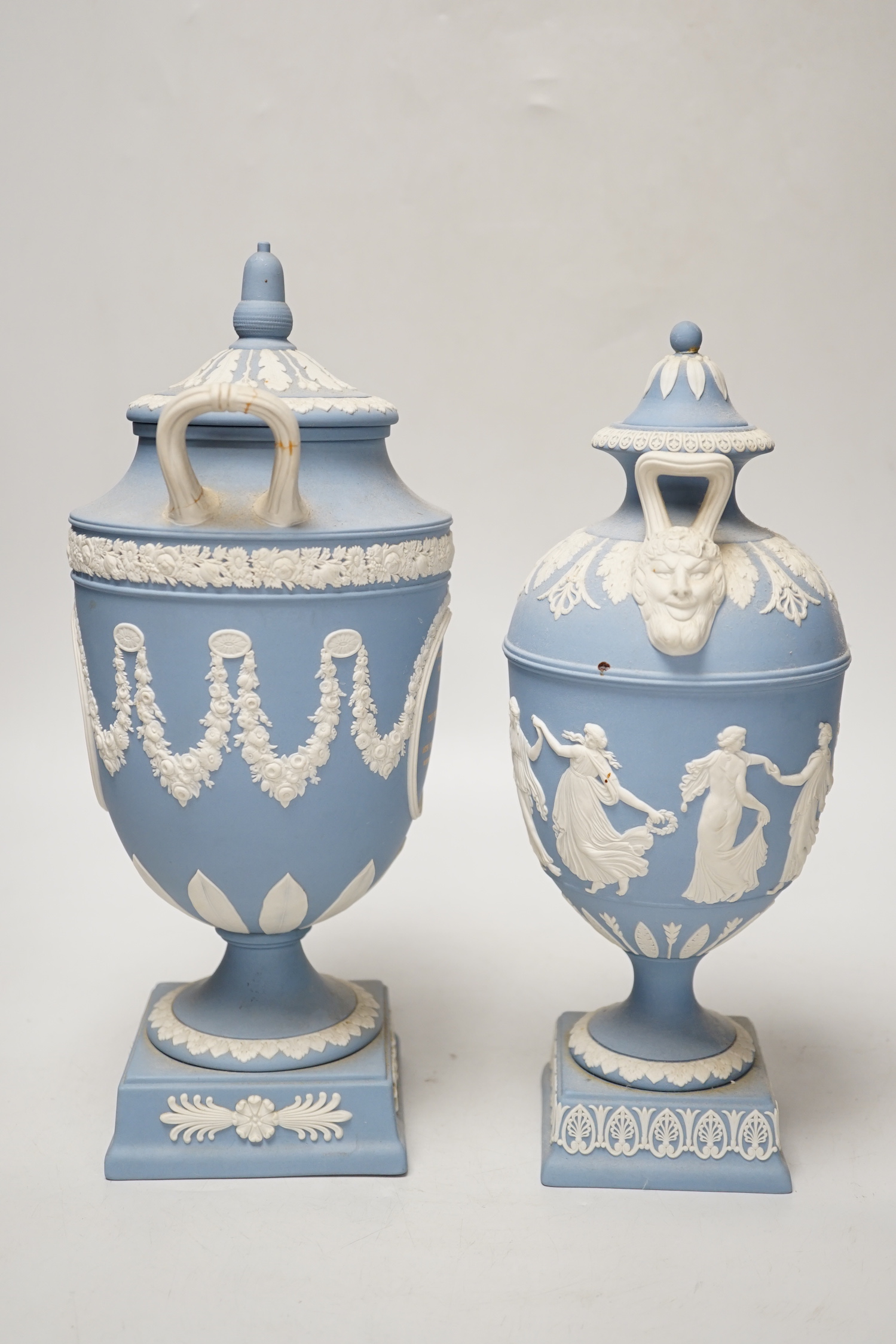 A Wedgwood blue jasper commemorative urn and cover and a similar smaller urn and cover, tallest 31cm
